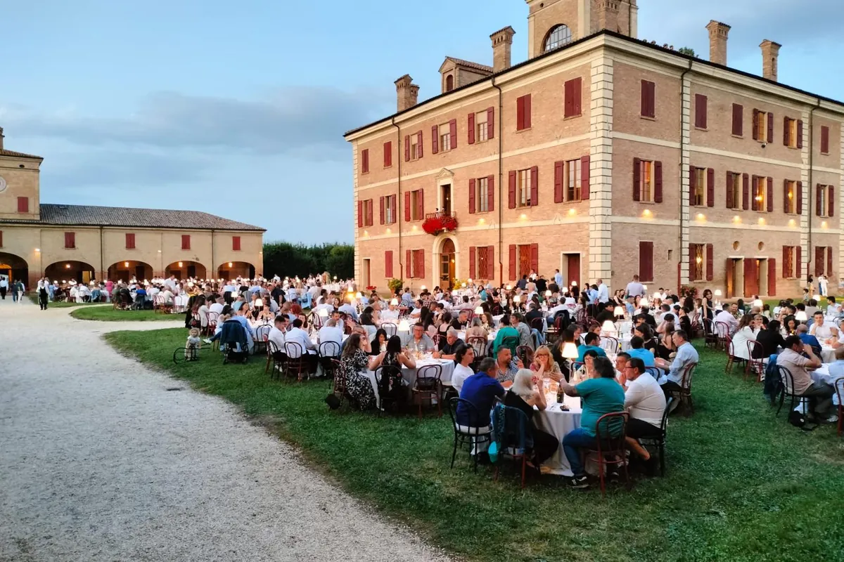 Cena aziendale all’aperto davanti a una villa storica al tramonto
