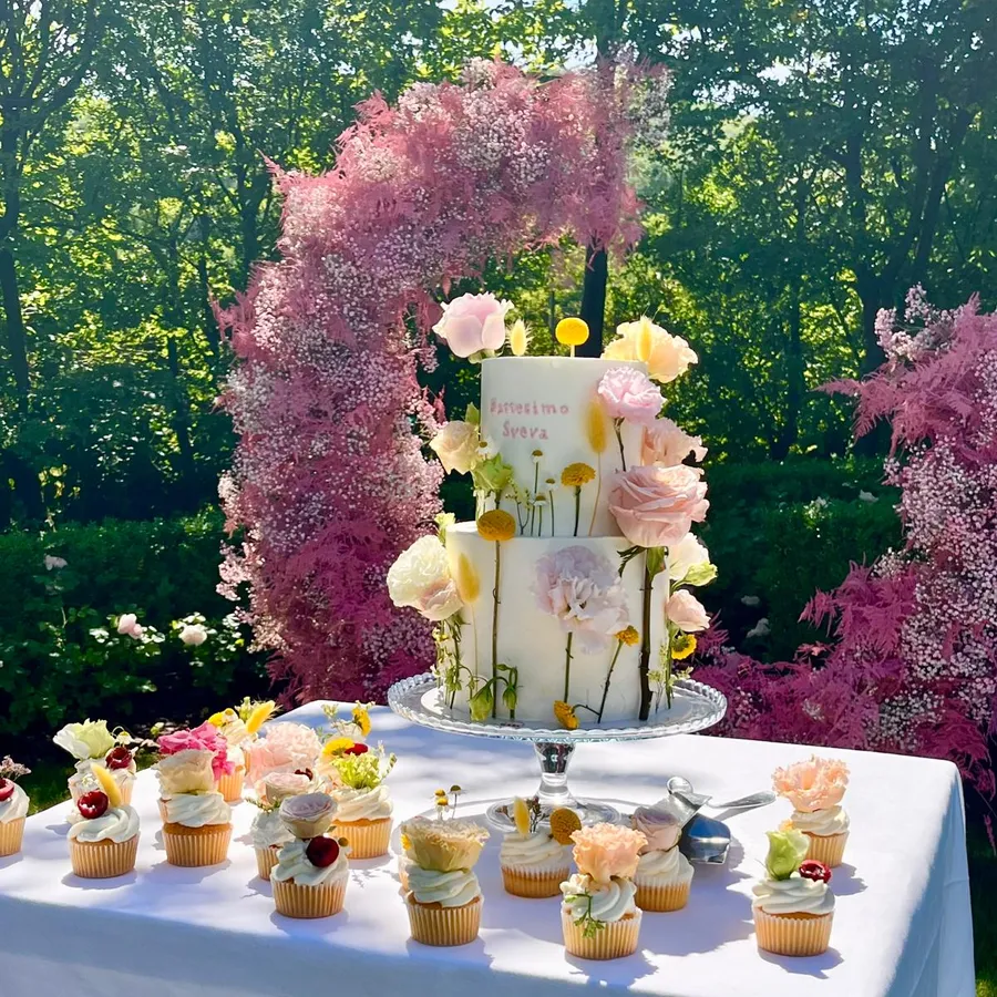 Torta e cupcake per un battesimo con arco di fiori