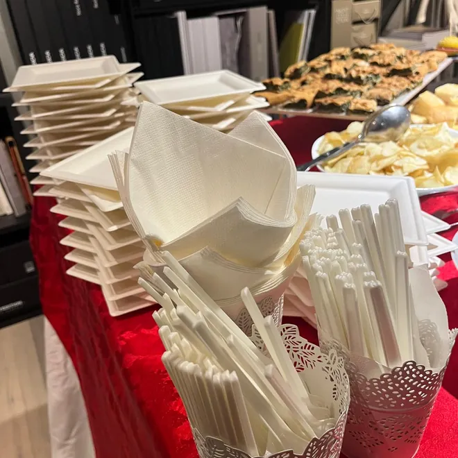 Piatti e posate compostabili impilati su un tavolo da buffet
